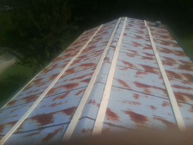 Rusted metal roof panels with new wood purlins before replacement — Storm Damage Roof Repair in Faith by Roofing Brothers