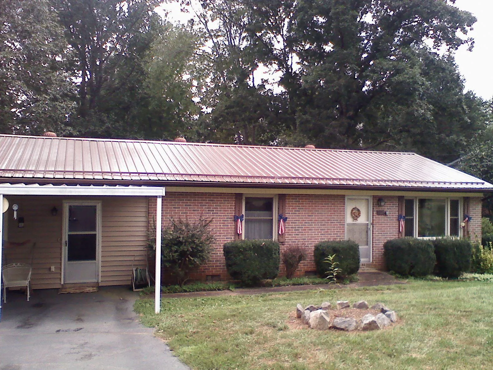 Bronze metal roof and carport on a brick ranch home — Roof Repair work by our crew in Faith
