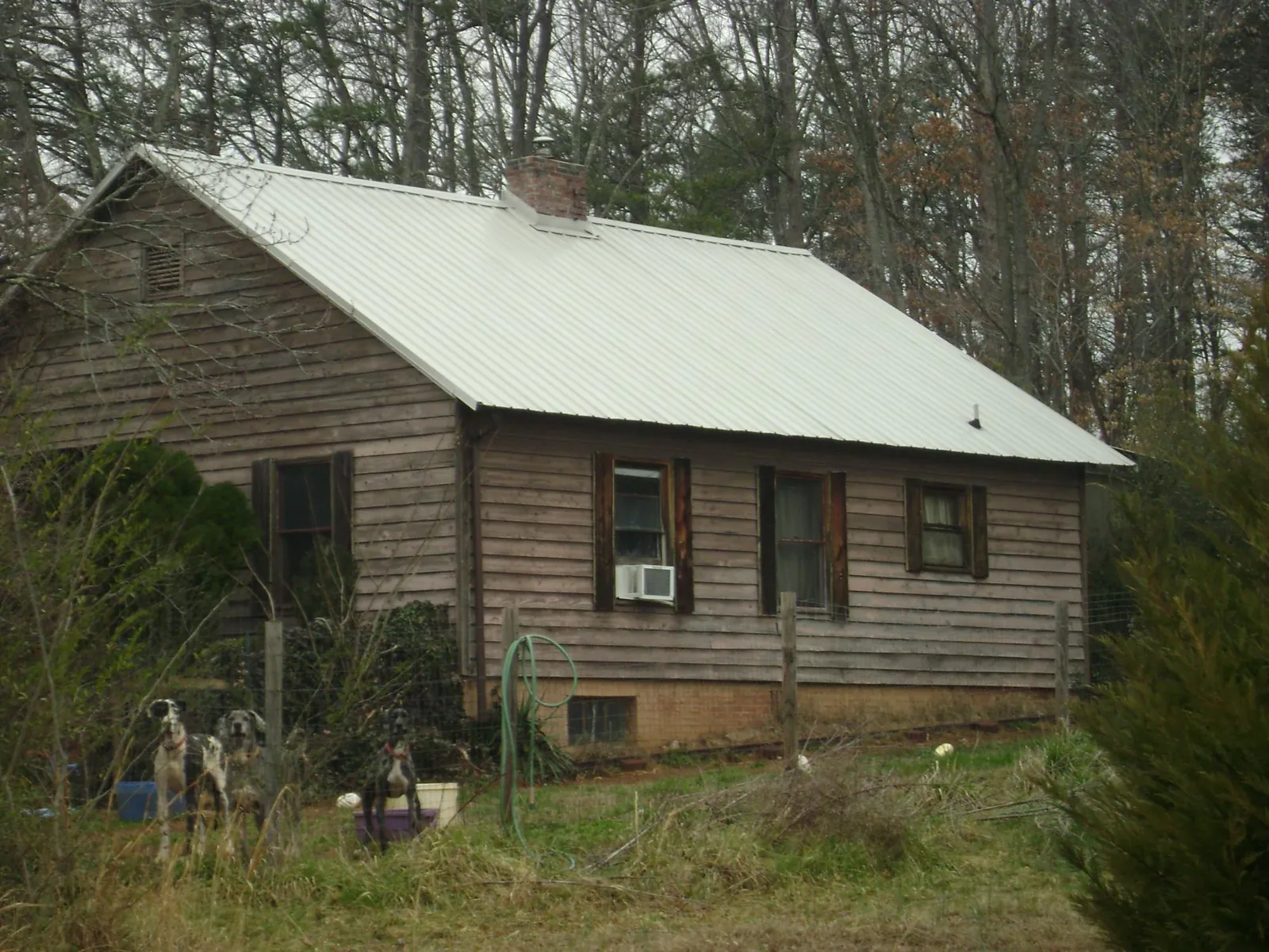 White metal roof on an old wood sided farmhouse, from a Metal Roof Installation job in Faith